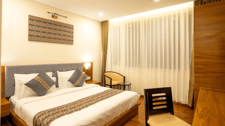 Elegant Deluxe Room at Voyage The Royal Retreat with plush bedding, warm lighting, and contemporary décor.