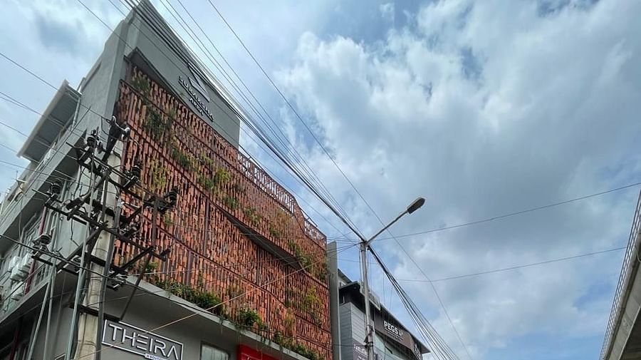 Facade image of Theira Fressotel, Bangalore with white clouds on blue sky in the background