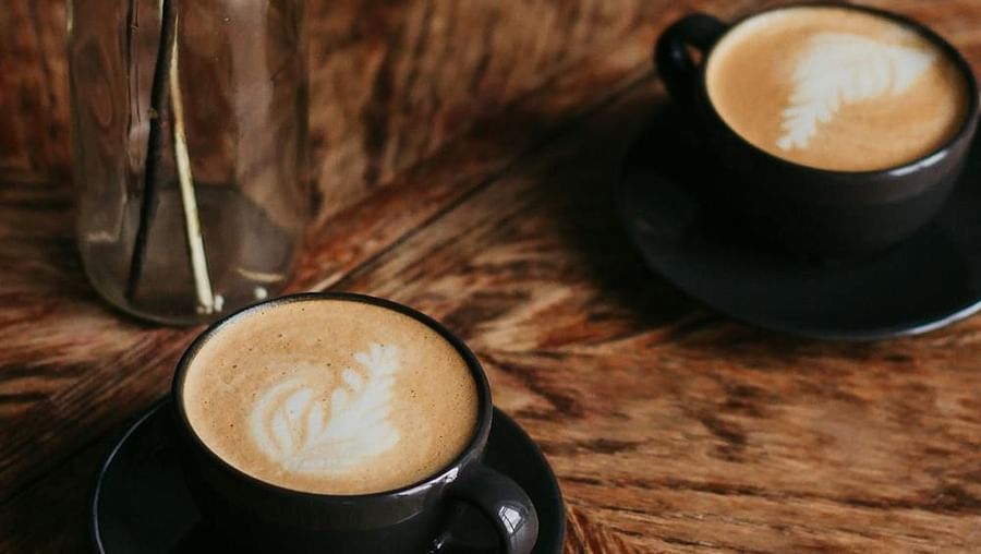 Image of two cups filled with coffee and a glass vase on the side - The Dukes Retreat, Khandala
