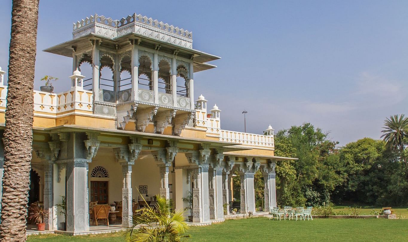 facade image of Dev Shree, deogarh featuring a vast levelled green lawn in the foreground during the day