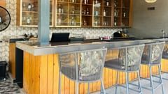 Clove bar at ABN Sarovar Portico, Jim Corbett with rows of metal high stool aligned in front of a yellow desk.