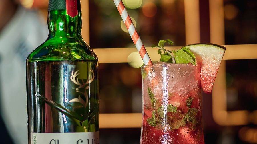A cocktail beside a bottle of Glenfiddich, with a soft focus on the background.