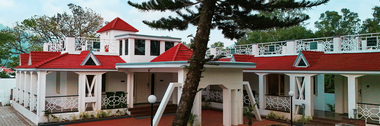 A facade image shot during day light of MGM Whispering Nest surrounded by greenery