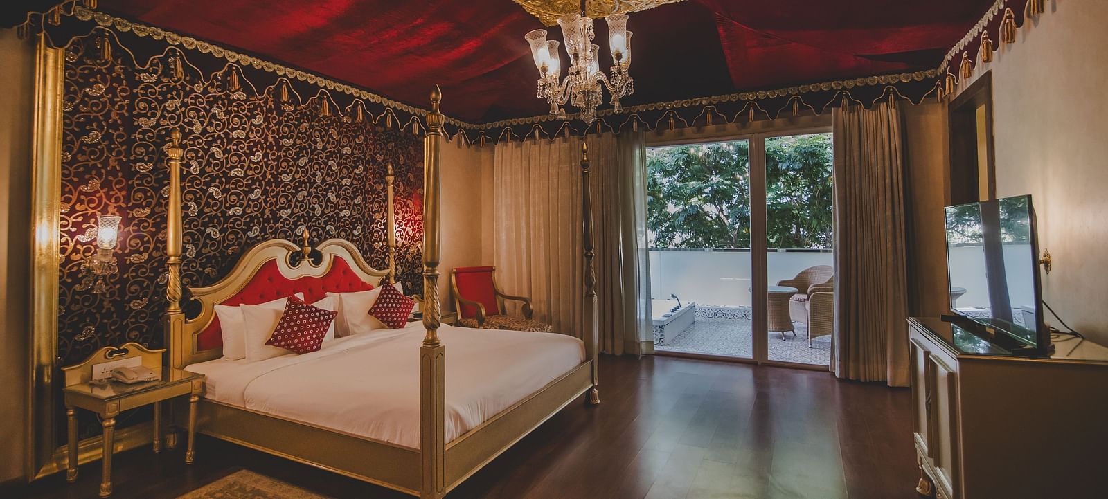 Image of a room with a bed and a chandelier above it at Rajasthali Resort & Spa Jaipur.