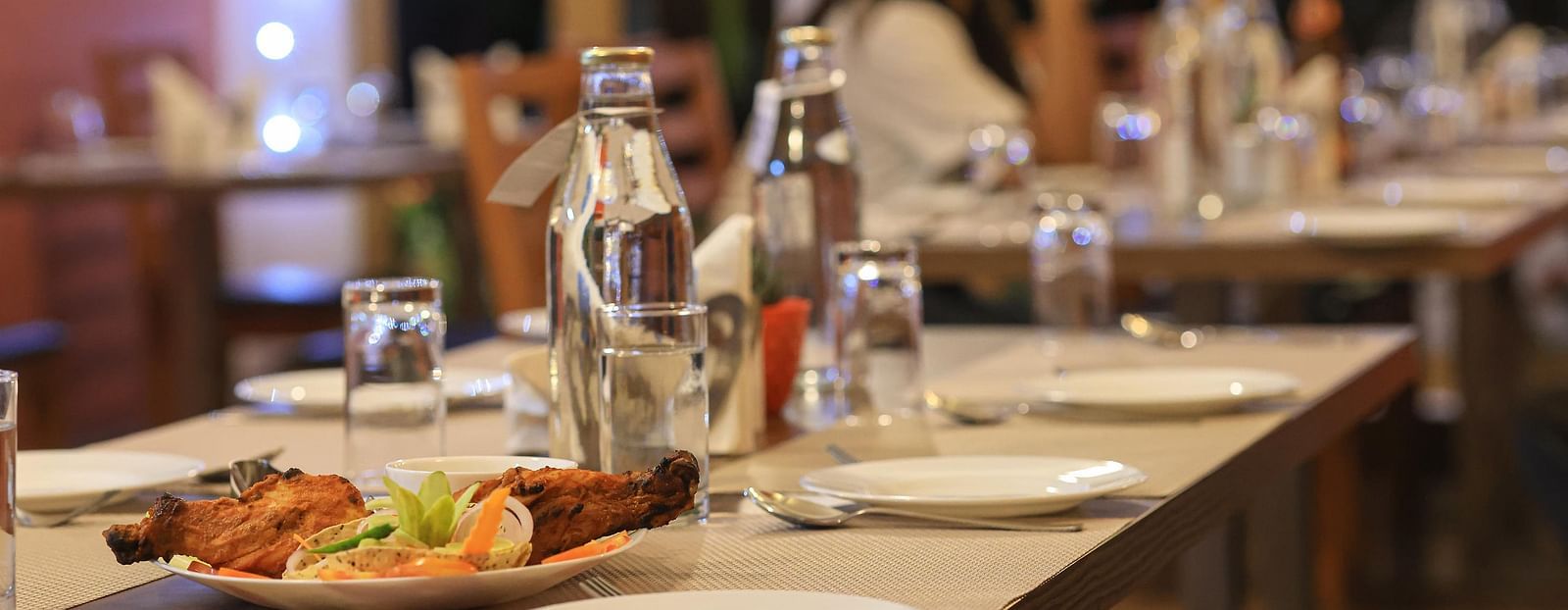 close up image of the dining table at blue charcoal with plates and cutlery set in Yashshree Karbari Resort & Spa, Yangang 
