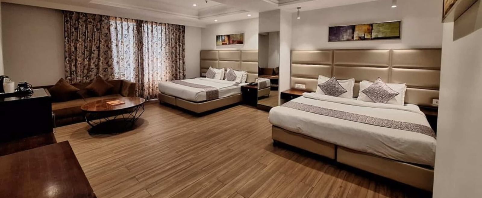 Family room at BluSalzz Select - City Centre, Amritsar with twin beds, seating area, and bright interiors.