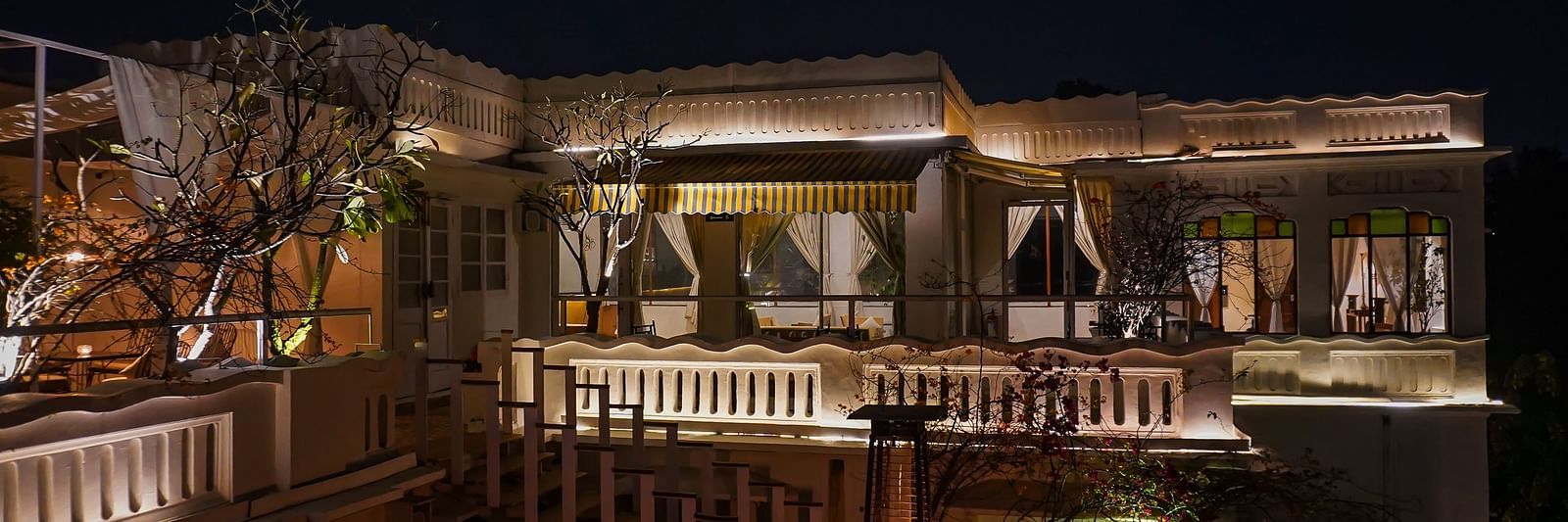 Exterior of well-lit Saraca Bar at Saraca Hotel, Lucknow at night