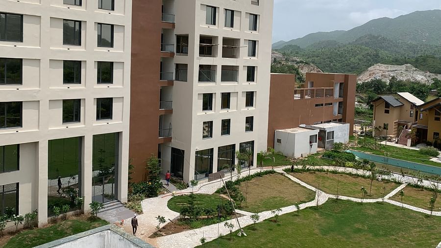 A drone view of Pride Resort Ambaji with the beautiful building and well maintained gardens is visible