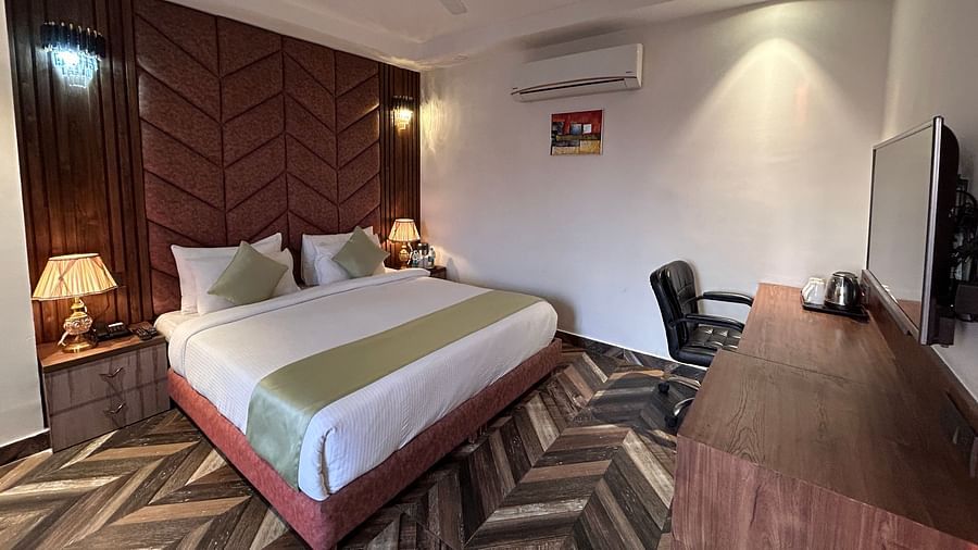 A deluxe room at DLS Grand Luxotica, Dehradun featuring a double bed in the middle of the room