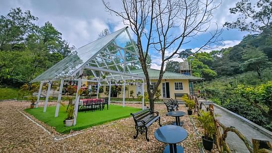 an image of a side view of outdoor space with chairs and tables at Ibex Stays & Trails, Valparai (Mistly)