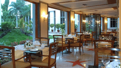 Bright and spacious seating with garden views at Aroma Multicuisine Restaurant at The Manohar, Hyderabad