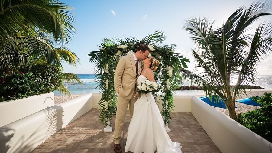 A newly wed couple kissing - The Soco Hotel Barbados