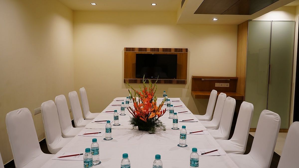 Board Room with a chair and table and a flower vase with bottle and Tv at Shervani Nehru Place, New Delhi