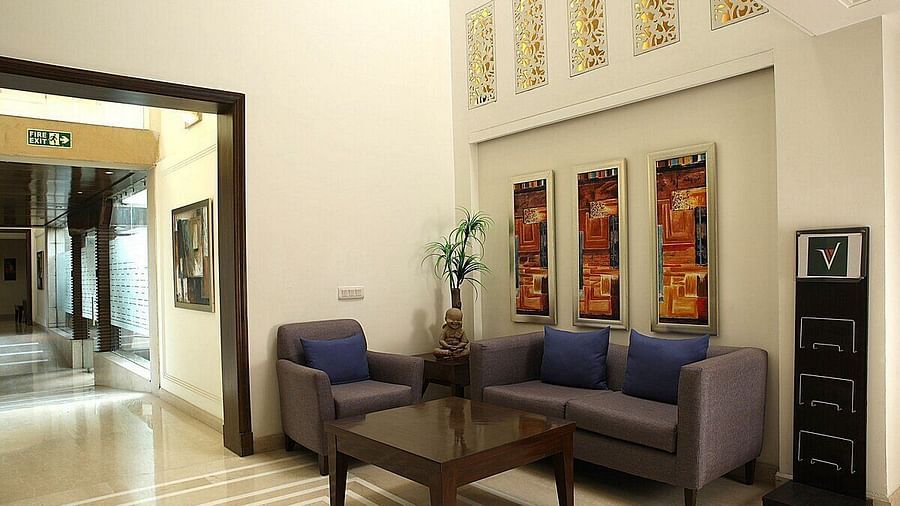 An image of a seating area in a lobby with sofa set and a centre table