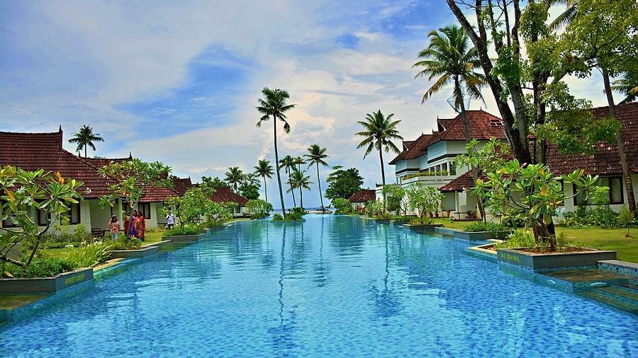 Swimming pool with greenery and building on either side - Rhythm Kumarakom