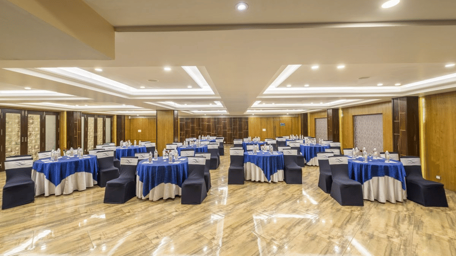 A conference room with round tables, blue tablecloths, and chairs arranged for an event - The Citrine, Bangalore