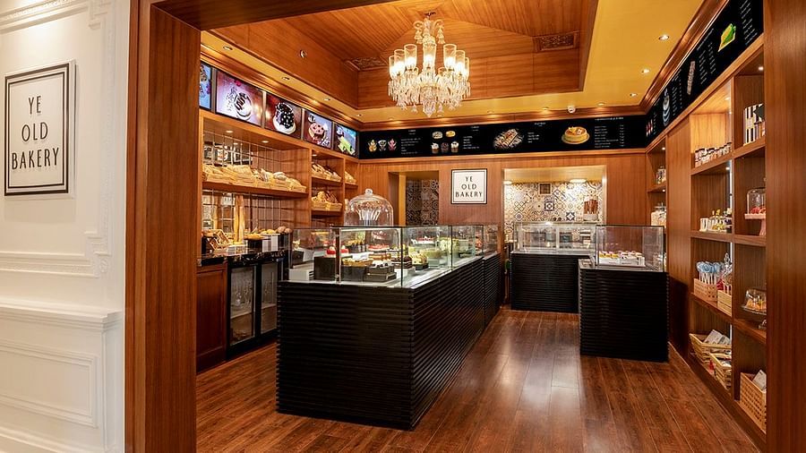 Ye Old Bakery at The Claridges New Delhi, showcasing an elegant chandelier and a curated selection of baked delights in a stylish glass display
