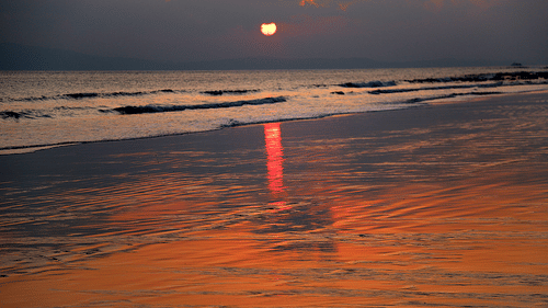 A view of the sunset at Radhanagar Beach with the reflection of the sun seen on the shores of the beach.