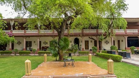 A facade image of Ranbanka Palace with a tiled centre piece in the lawn