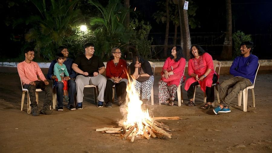 Campfire - Sajan - a group of 8 peopl sitting on chairs surrounding a camp fire and enjoying long talks.