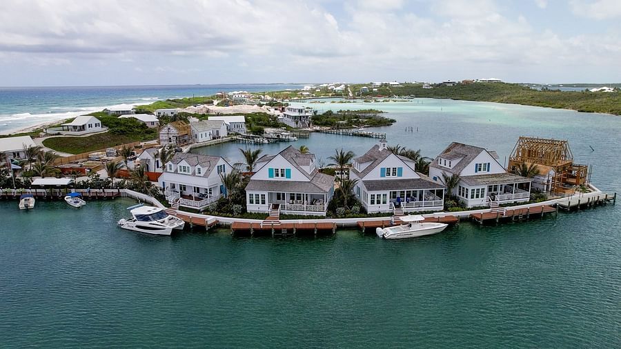 Marina scene with small boats docked near a group of seaside cottages and overwater villas in a protected inlet | Abaco Inn