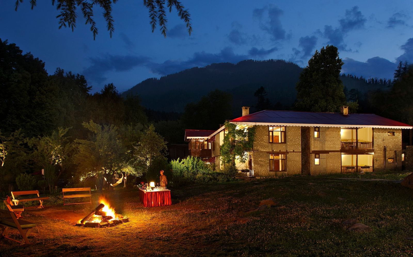 Bonfire in the outdoor with facade of Bedzzz Xclusiv Baikunth in the background