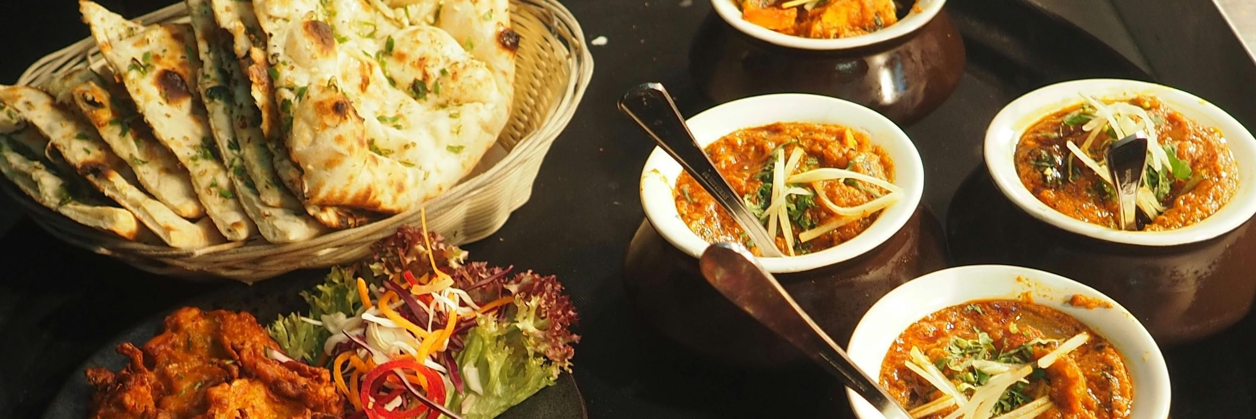 Different kinds of foods arranged on a table in different bowls and plates