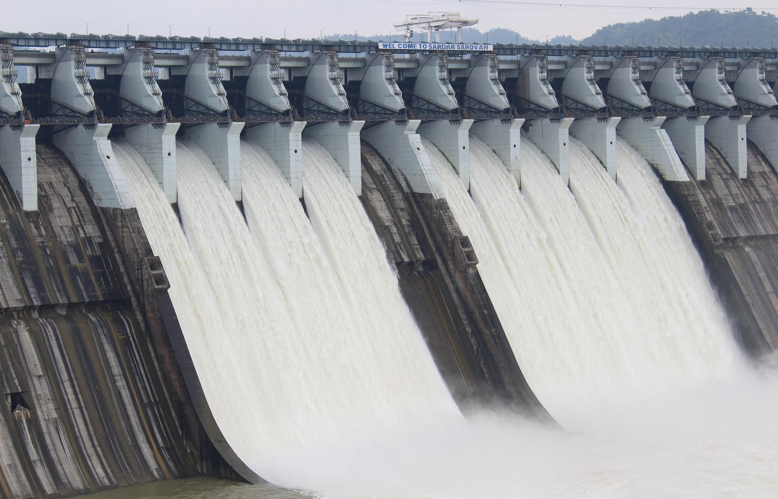 A dam with powerful flowing water cascading over its edge, creating a dramatic and dynamic scene.