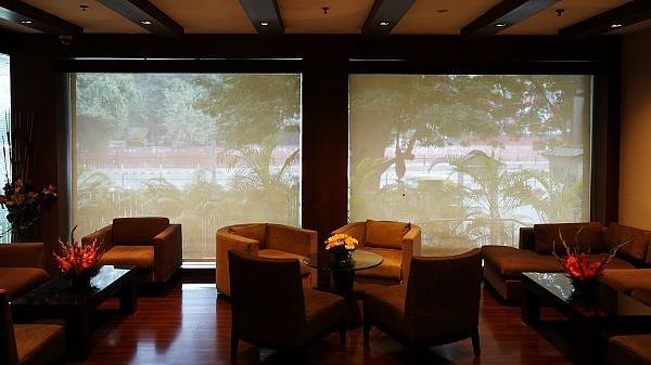 sofa arranged against a large window at Shervani Nehru Place, New Delhi