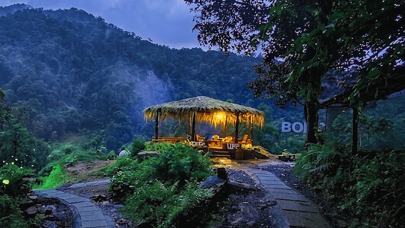 Holistic Eco-Resort | Facade with mountains and sky in the backdop at night.