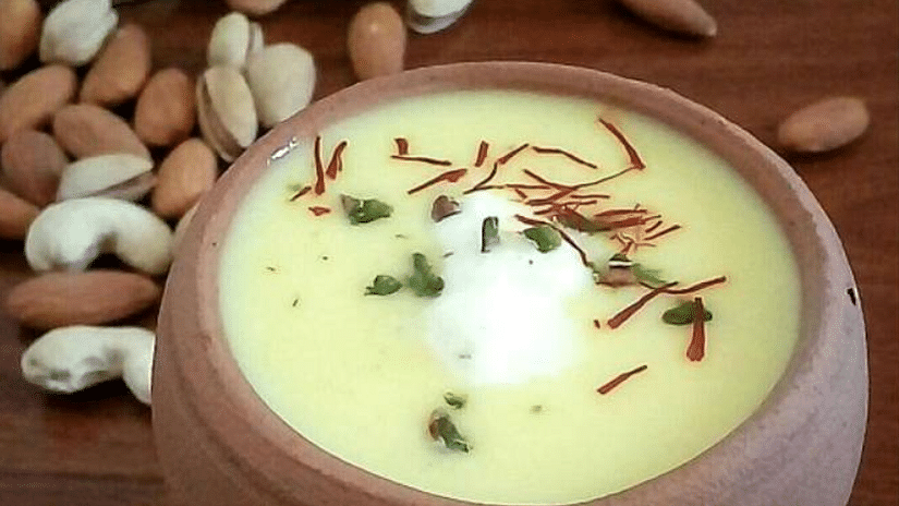 A top view of Makhania Lassi served in an earthen glass, beautifully garnished with saffron and a selection of dry fruits, highlighting its rich and inviting presentation.