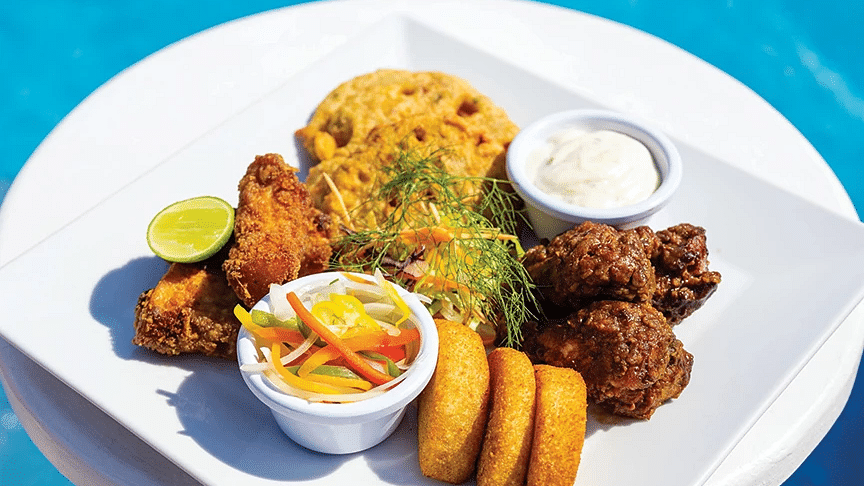 Colourful plate of Caribbean cuisine with plantains and dipping sauce - S Hotel Kingston, Jamaica