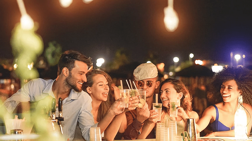 A group of friends enjoying a lively outdoor dining experience at night - S Hotel Kingston, Jamaica