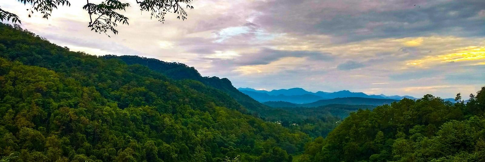a mesmerising landscape of dehradun with a beautiful sky with clouds in the background