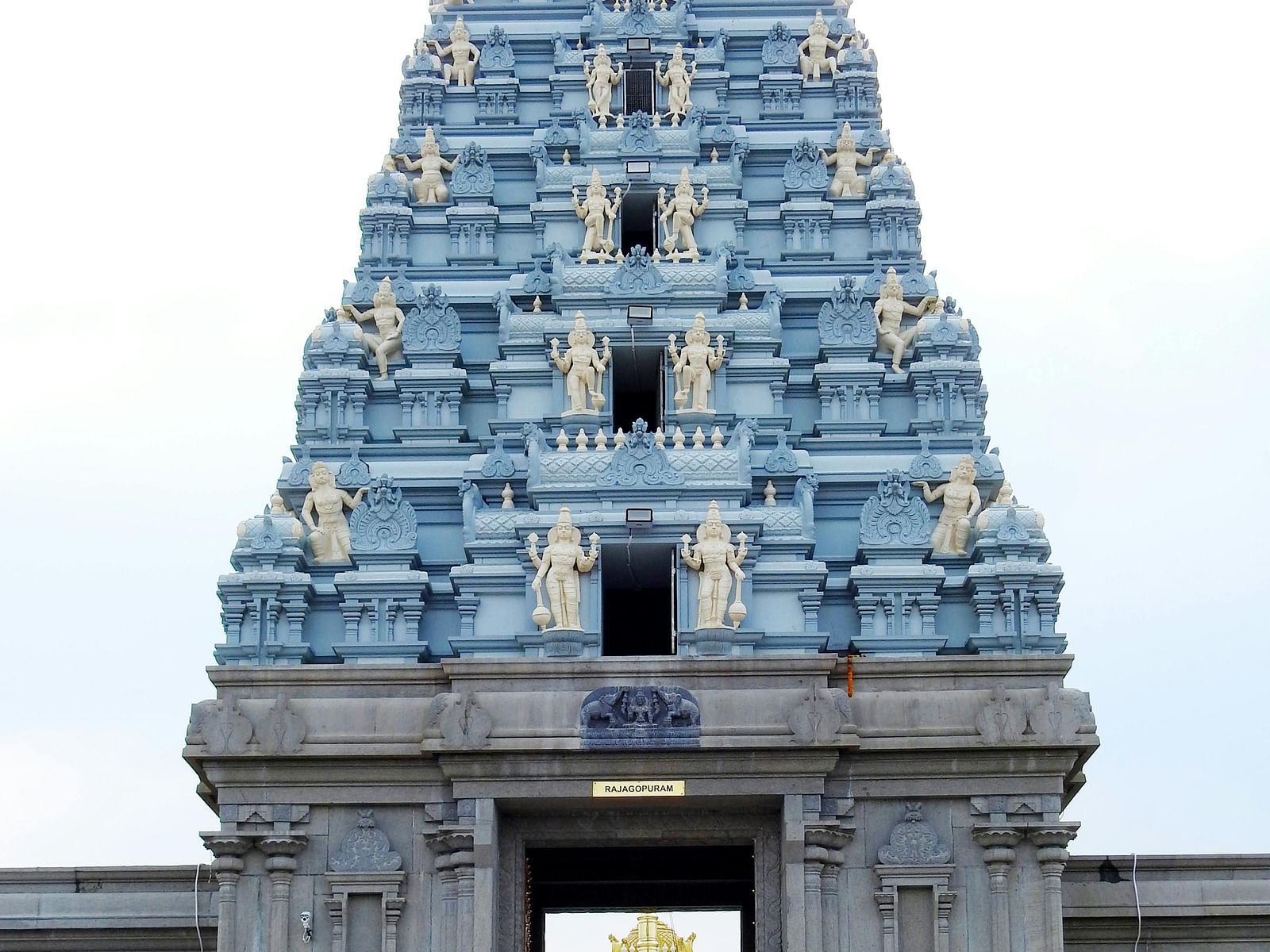 A grand temple entrance with a towering gopuram adorned with intricate carvings and sculptures.