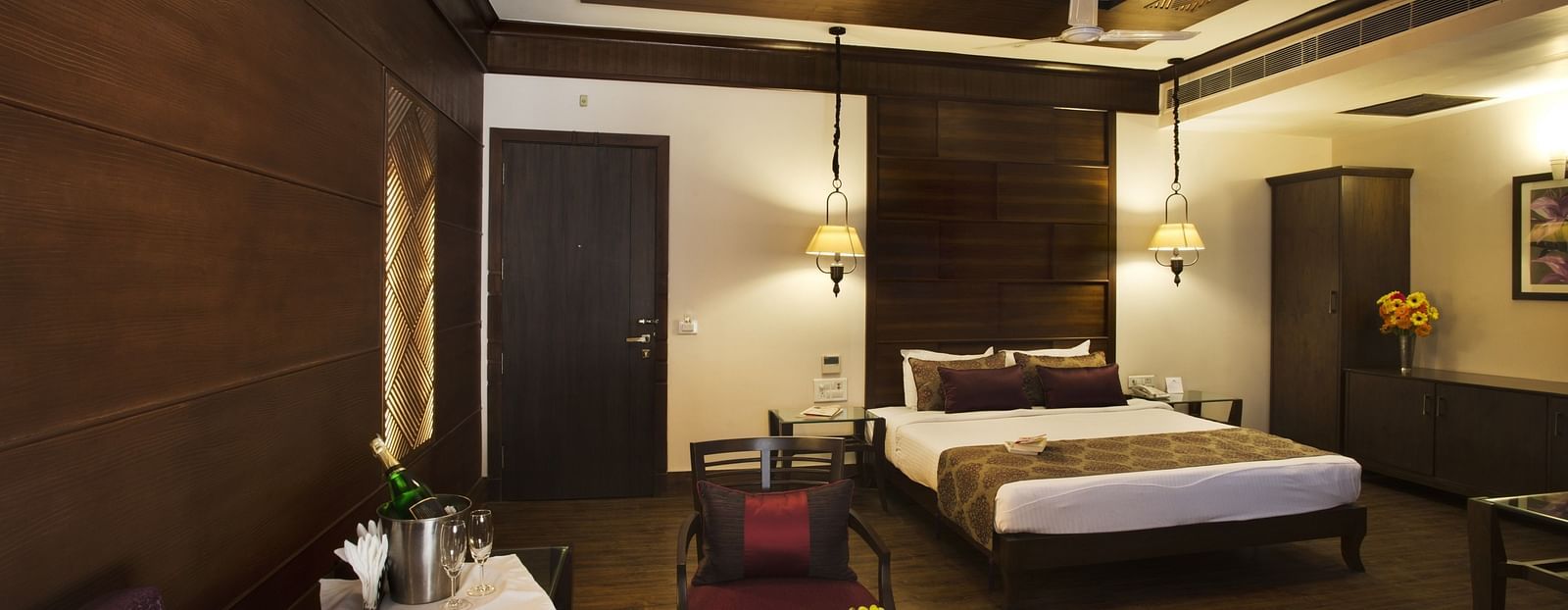 A front view of a bed and table in a room | The Manor, Kashipur