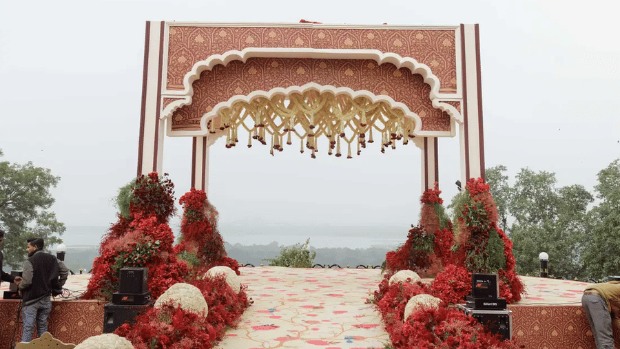 A beautiful mandap with flowers hanging from the top overlooking the lake in the background from the Barbeque Lawn at Noor-Us-Sabah Palace, Bhopal.