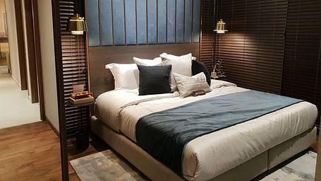 A hotel bed room with a plush bed, ambient lighting