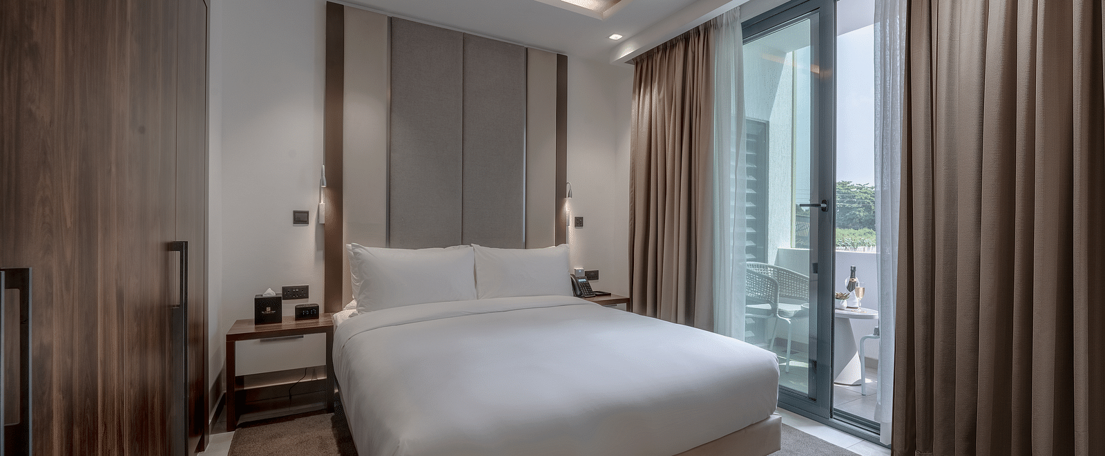 A spacious, well-lit Executive Suite featuring a king size bed and floor-to-ceiling windows - The Pelican Hotel, Accra - Place To Stay in Accra, Ghana, with Family.