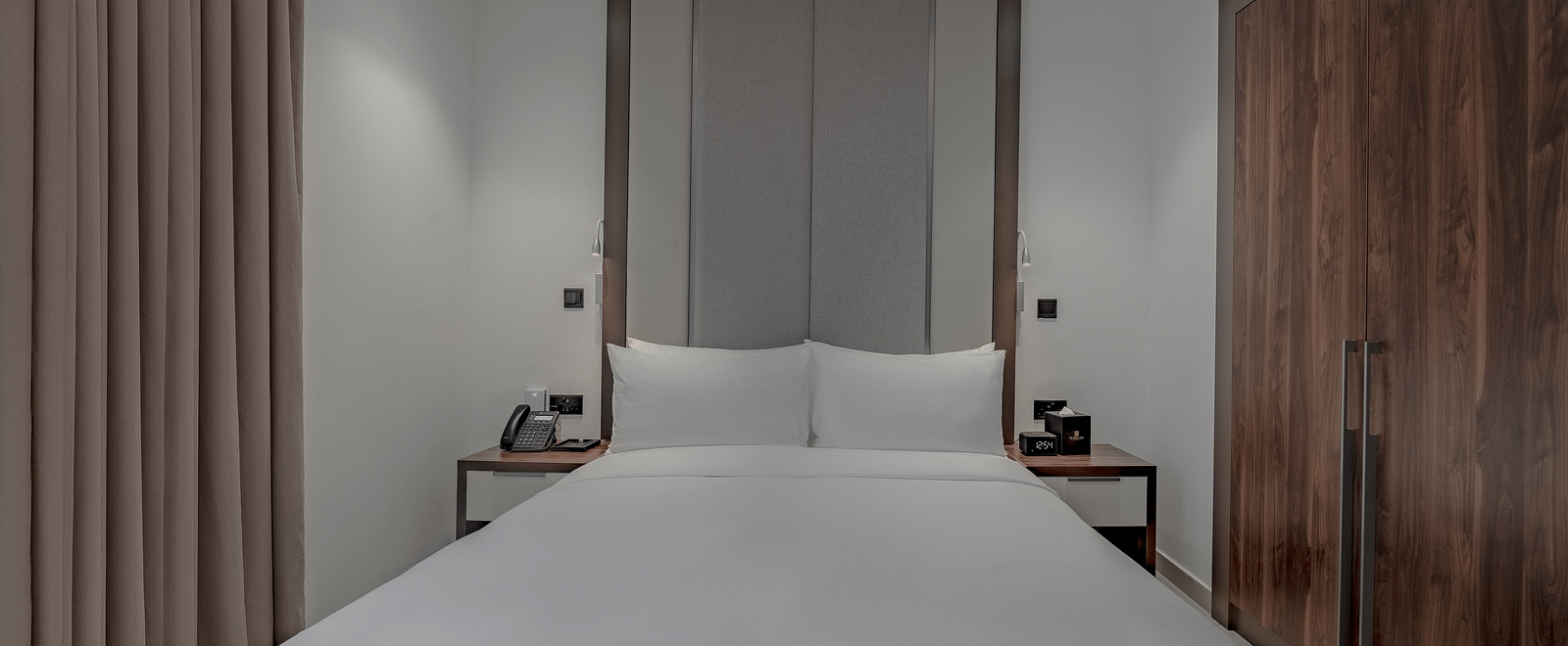 A king size bed in a well-lit Premier Suite. - The Pelican Hotel, Accra