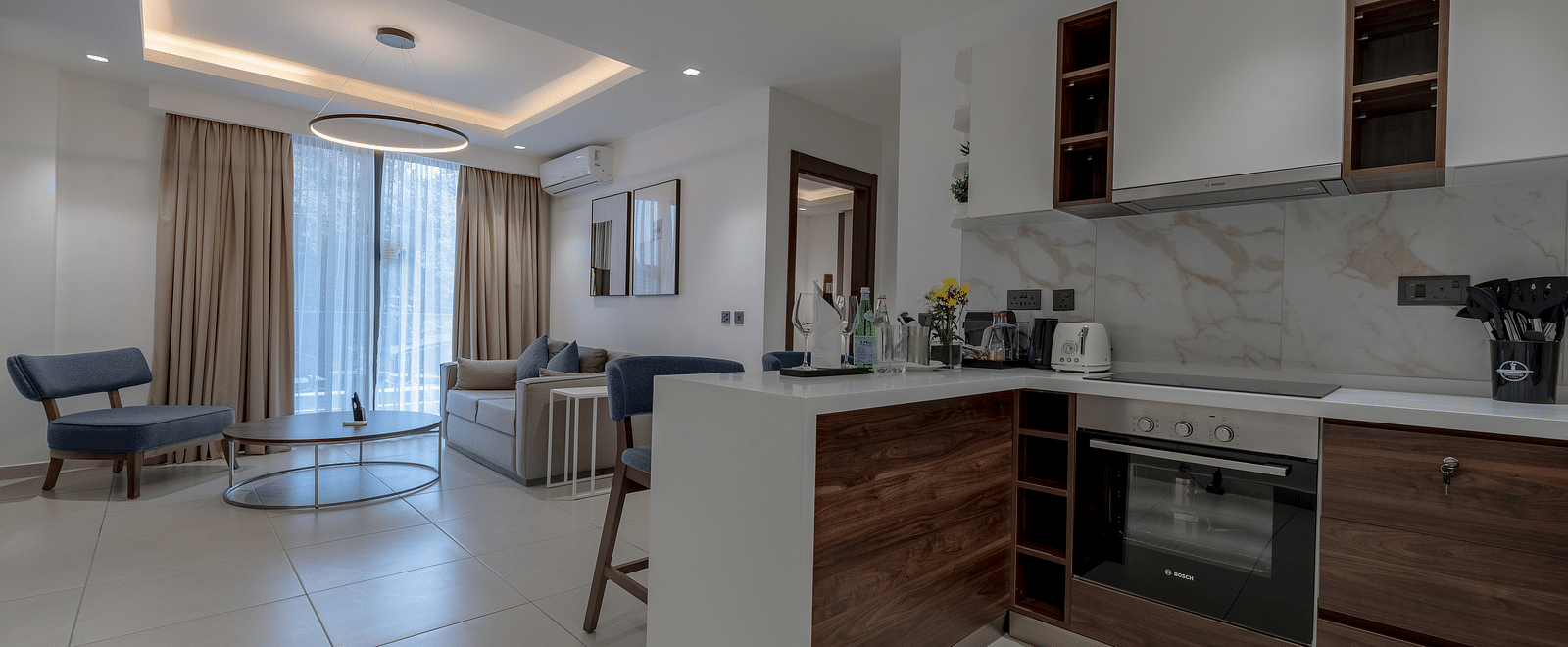 Modern kitchen in a Premier Suite with stainless steel appliances and wood cabinetry. - The Pelican Hotel, Accra