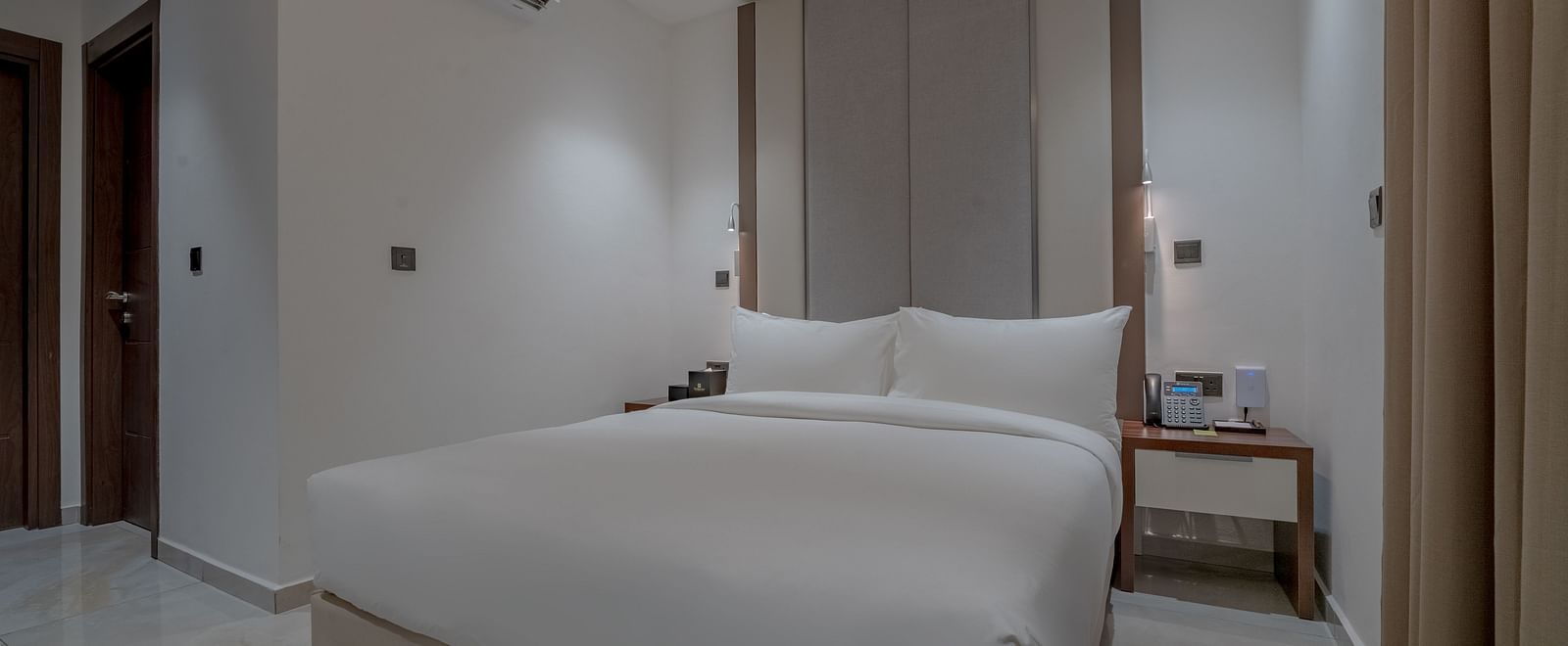 Elegant, spacious Deluxe Room with a comfortable bed, bedside tables, and modern decor. - The Pelican Hotel, Accra