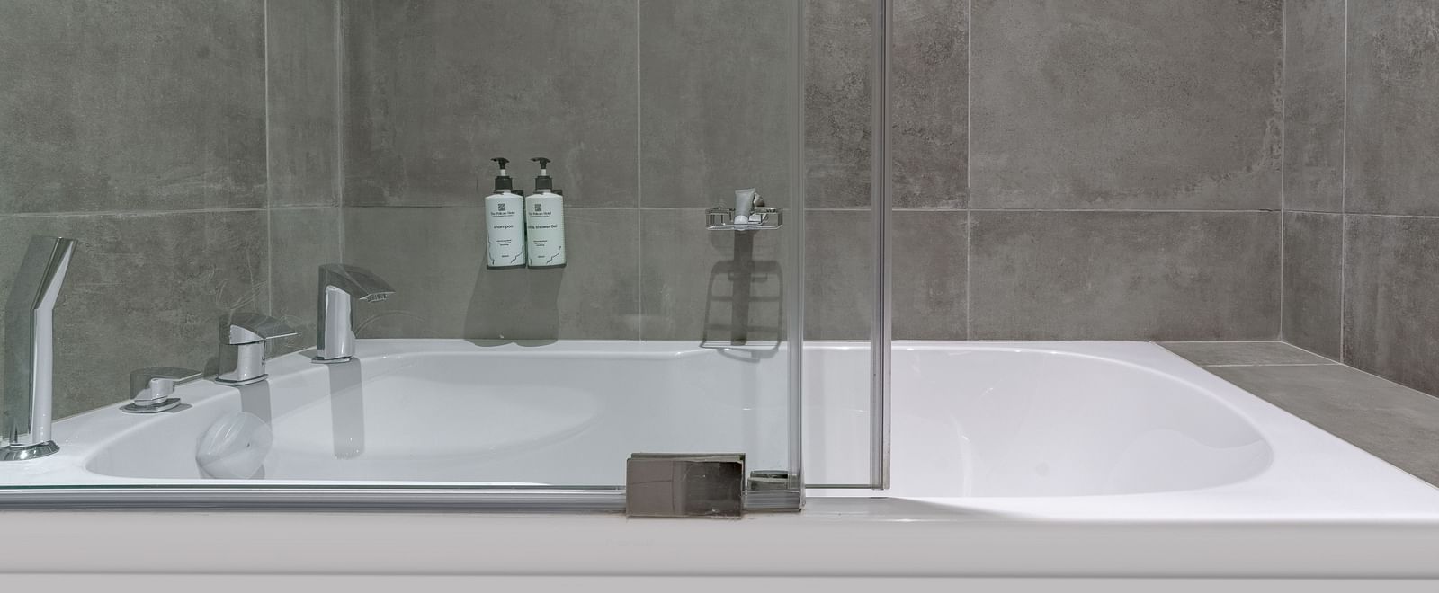 Modern Junior Suite with a bathtub, and a glass shower door. - The Pelican Hotel, Accra