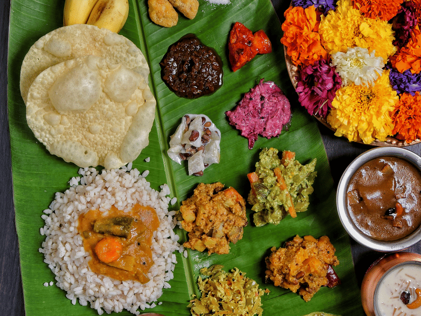 Lavish Onam sadya displayed on a banana leaf with rice, curries, sweets, and traditional vegetarian dishes served during celebrations