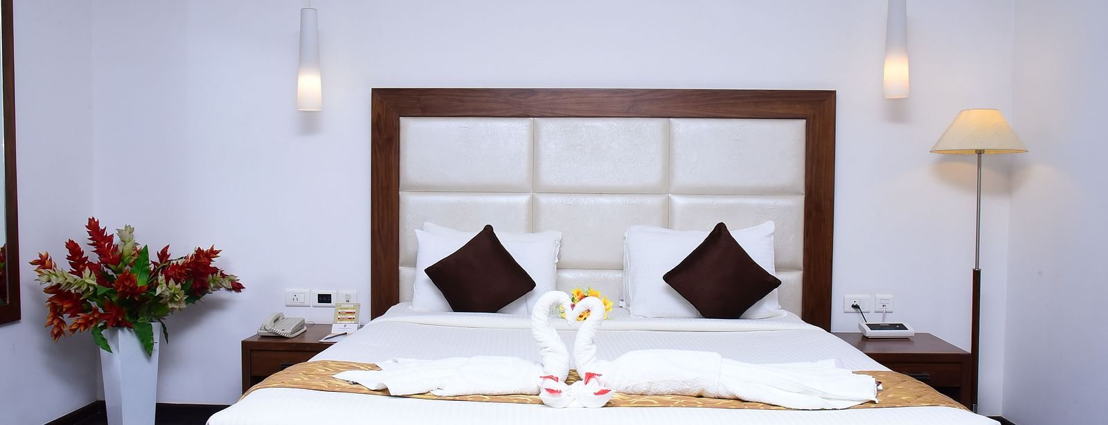 A luxurious suite featuring a king-sized bed, elegant decor, and ambient lighting for a restful retreat.- Dhanalakshmi Srinivasan Hotels, Perambalur
