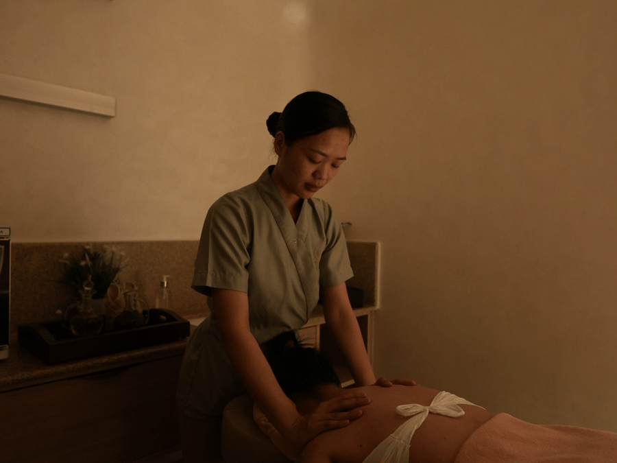 A woman providing a shoulder massage service in a spa at Karma Lakelands