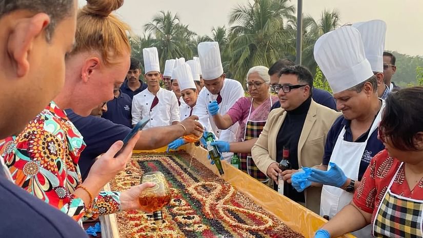 An image of chefs and many guests decorating cake with dry fruits - Cloud9 Sarovar Premiere, Palolem Goa
