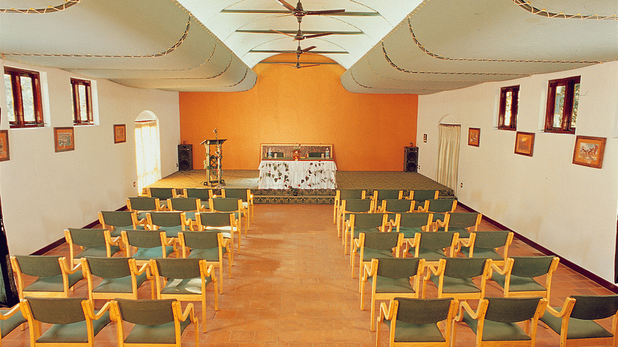 A back view of chairs placed in classroom seating in a closed hall | Vythiri Resort, Wayanad