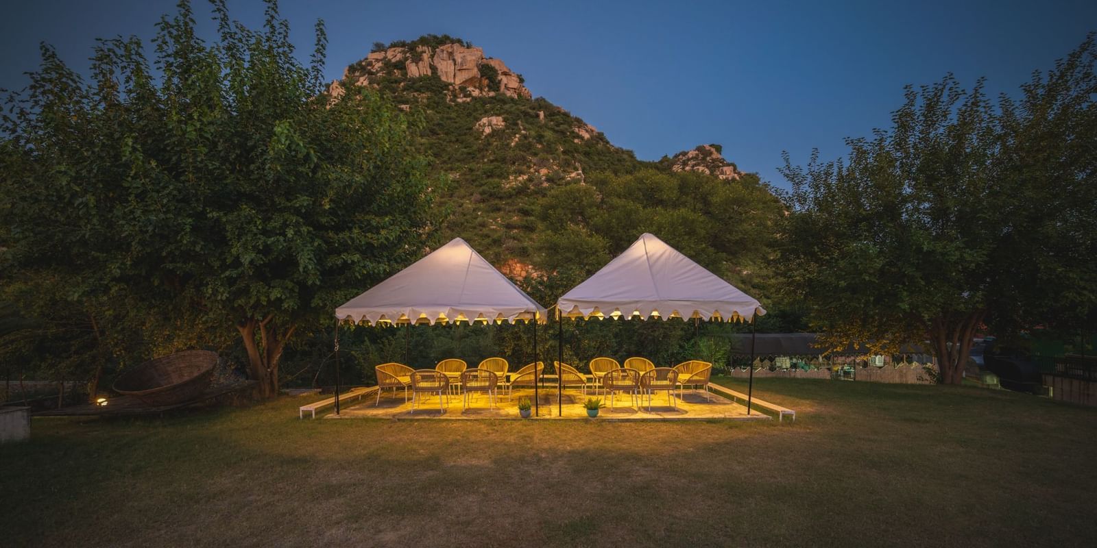 Night view of an open dining space adorned with sheer curtains and glowing lights at Valley by Grassfield.