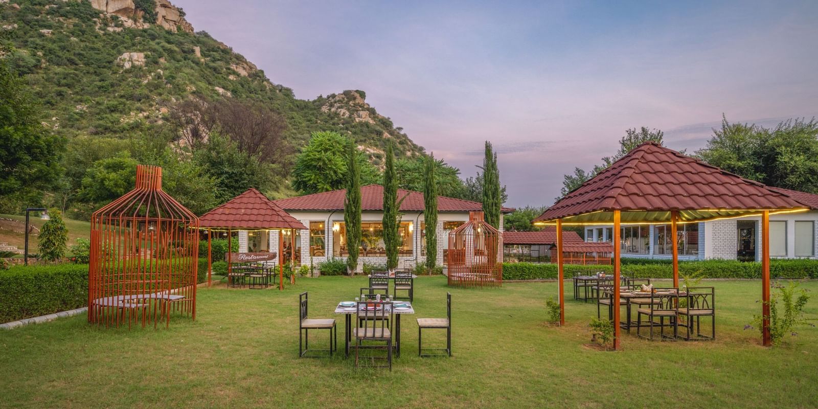 An open space at Valley by Grassfield, featuring tables and chairs, with mountains providing a stunning backdrop.